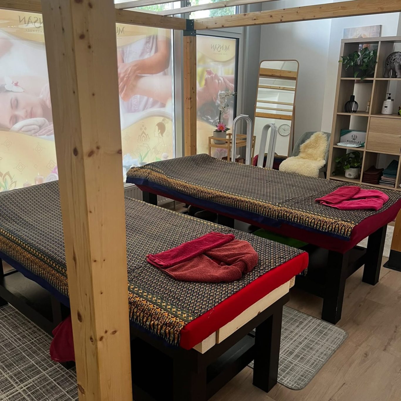 Paarmassageraum bei Munsan mit zwei nebeneinanderstehenden Massageliegen und roten Handtüchern